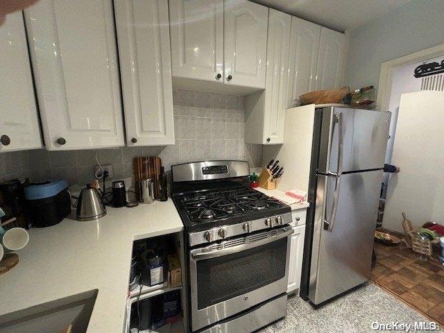 kitchen featuring decorative backsplash, stainless steel appliances, and white cabinetry