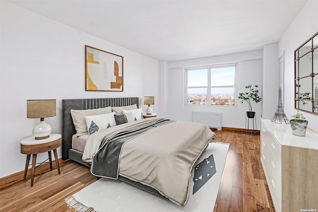 bedroom featuring wood-type flooring and radiator heating unit