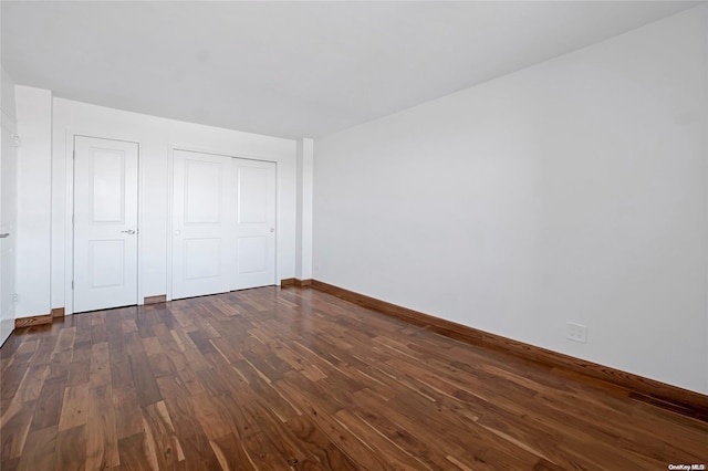 unfurnished bedroom with dark wood-type flooring