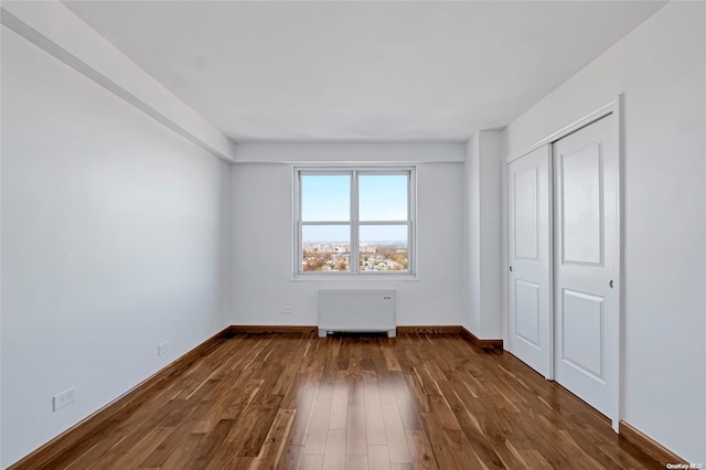 unfurnished bedroom with a closet and dark wood-type flooring