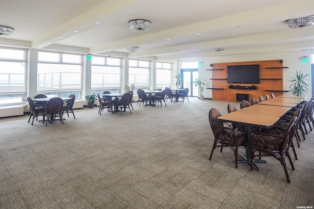 dining space with beamed ceiling and carpet floors