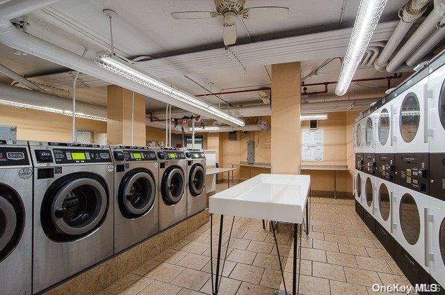 laundry room with washer and dryer, stacked washing maching and dryer, and ceiling fan