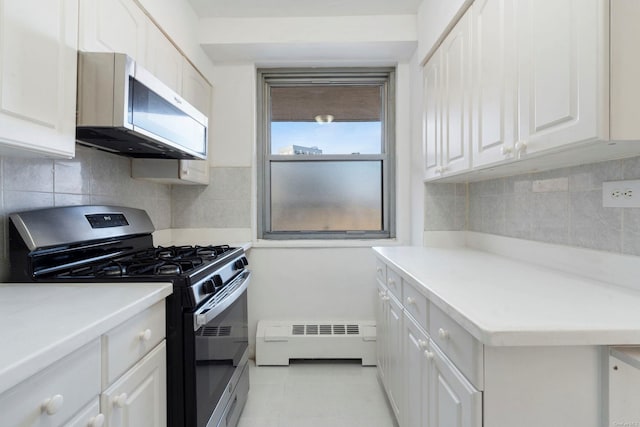 kitchen featuring stainless steel appliances, a baseboard radiator, white cabinetry, and light tile patterned flooring