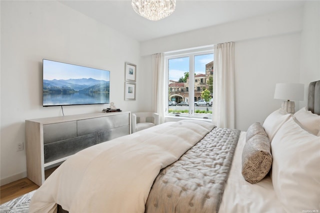 bedroom featuring hardwood / wood-style floors and an inviting chandelier