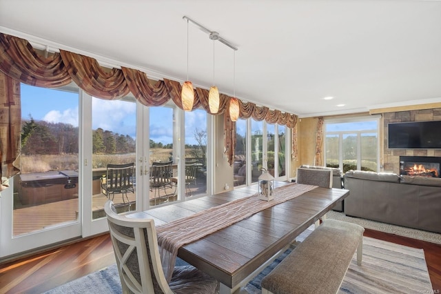 dining area with dark hardwood / wood-style flooring, a tile fireplace, and crown molding