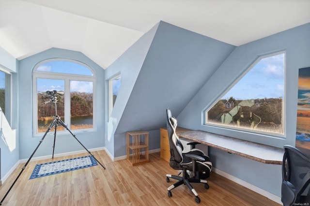 office featuring lofted ceiling and light hardwood / wood-style floors