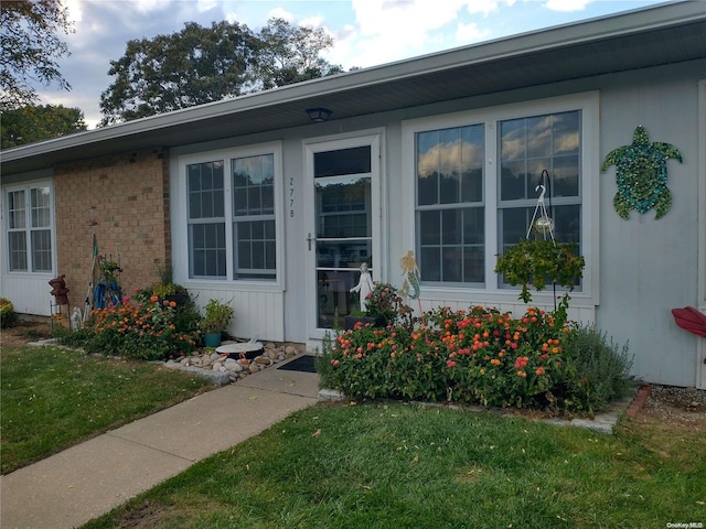 view of exterior entry featuring a yard