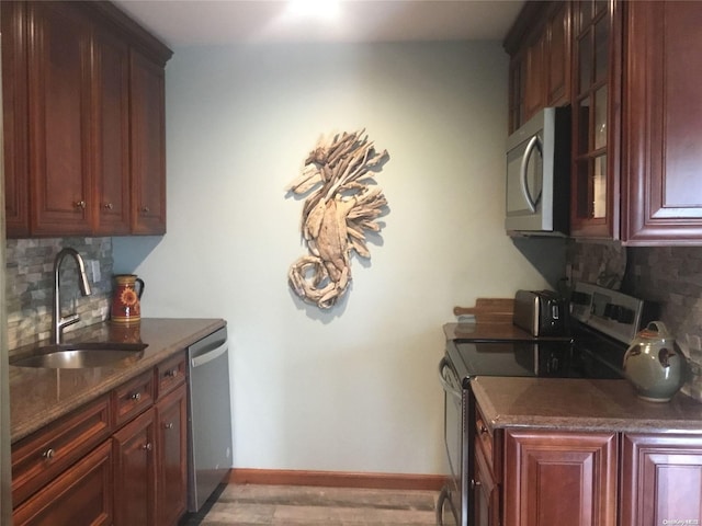 kitchen featuring decorative backsplash, sink, light hardwood / wood-style flooring, and appliances with stainless steel finishes