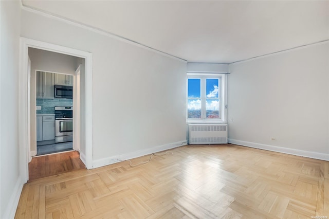 unfurnished room featuring light parquet floors and radiator