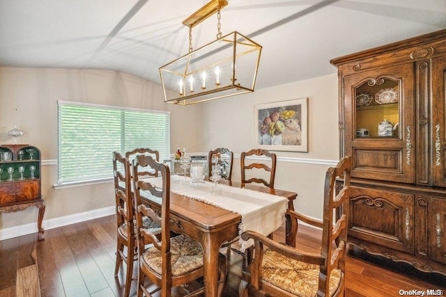 dining area with a chandelier, vaulted ceiling, and dark wood-type flooring