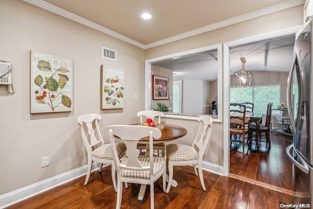 dining area with crown molding and dark wood-type flooring