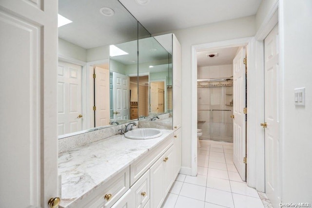 bathroom with tile patterned flooring, vanity, and toilet