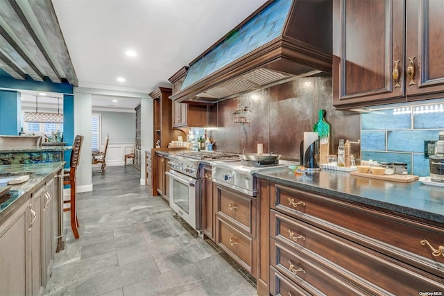 kitchen featuring decorative backsplash, custom range hood, high end stainless steel range oven, and dark stone counters