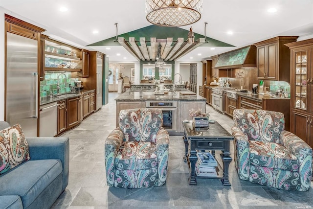 kitchen with custom exhaust hood, high quality appliances, stone counters, hanging light fixtures, and tasteful backsplash