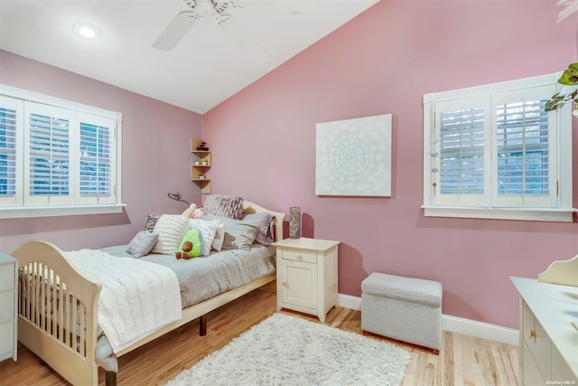 bedroom with ceiling fan, light hardwood / wood-style flooring, and vaulted ceiling