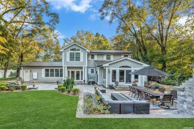 back of house with outdoor lounge area, a patio, a lawn, and french doors