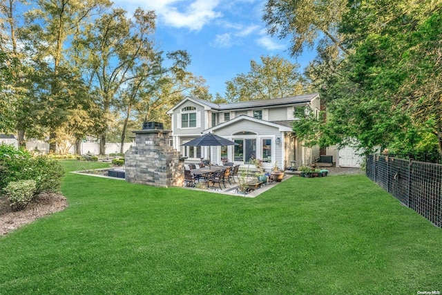 rear view of house featuring a yard and a patio