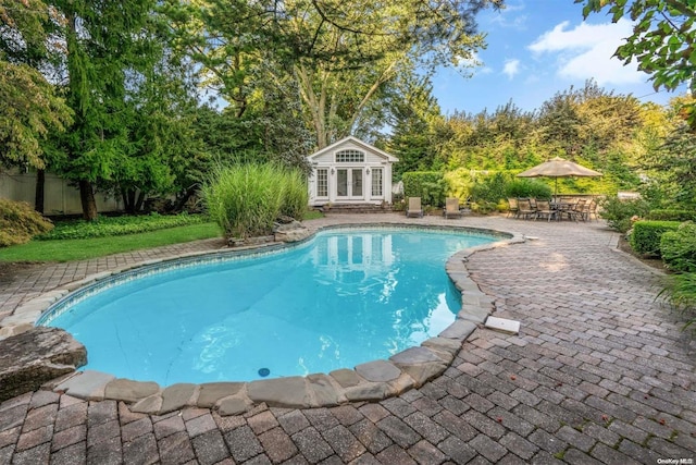 view of swimming pool with an outbuilding and a patio