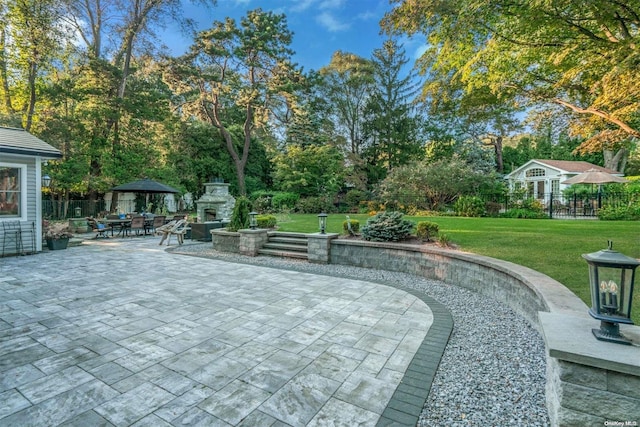 view of patio with a fireplace and a gazebo