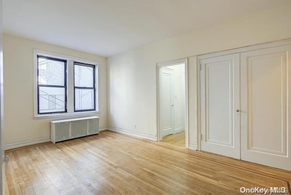 interior space featuring light wood-type flooring and radiator heating unit