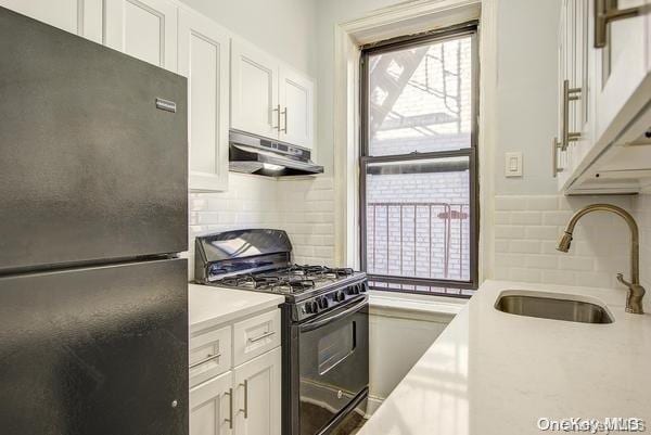 kitchen with black appliances, white cabinetry, and sink