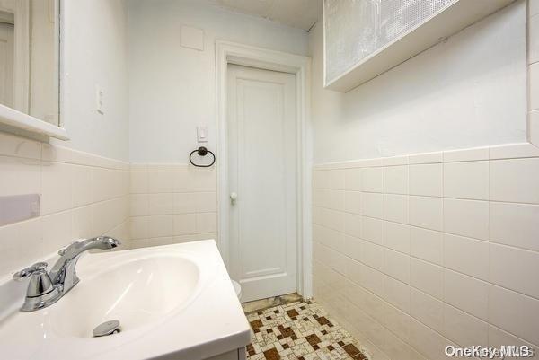 bathroom featuring vanity and tile walls