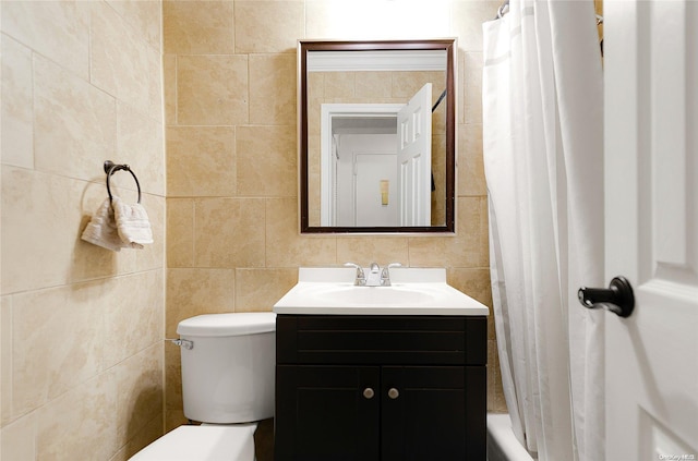 bathroom featuring vanity, toilet, and tile walls