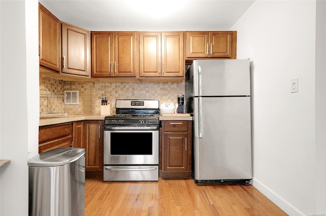 kitchen featuring light hardwood / wood-style floors, backsplash, and appliances with stainless steel finishes