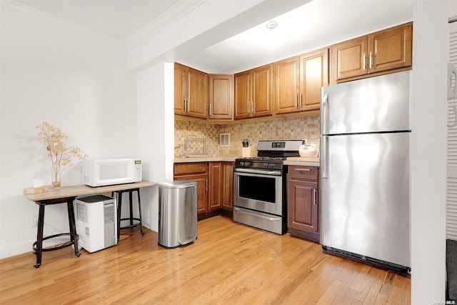 kitchen featuring tasteful backsplash, light hardwood / wood-style flooring, stainless steel appliances, and ornamental molding