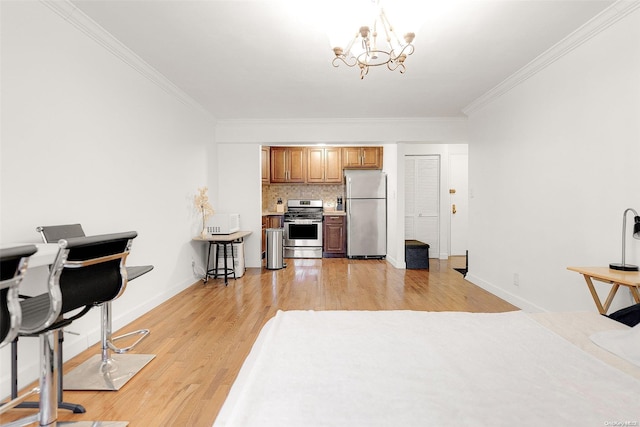 kitchen featuring decorative backsplash, ornamental molding, stainless steel appliances, an inviting chandelier, and light hardwood / wood-style floors