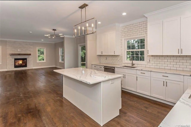 kitchen with white cabinetry, dishwasher, sink, a center island, and decorative light fixtures