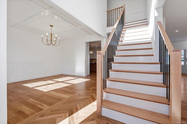 stairs with parquet flooring and a chandelier