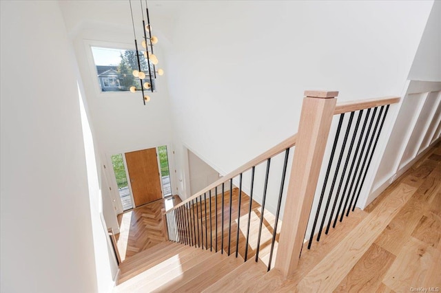 staircase with a notable chandelier