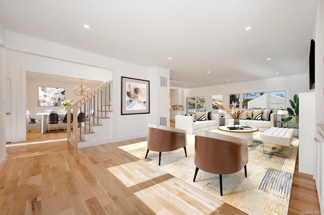 living room featuring light hardwood / wood-style floors and an inviting chandelier