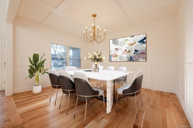 dining space featuring an inviting chandelier, light hardwood / wood-style flooring, and coffered ceiling