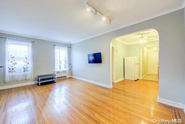 spare room with ceiling fan, light hardwood / wood-style flooring, track lighting, and ornamental molding