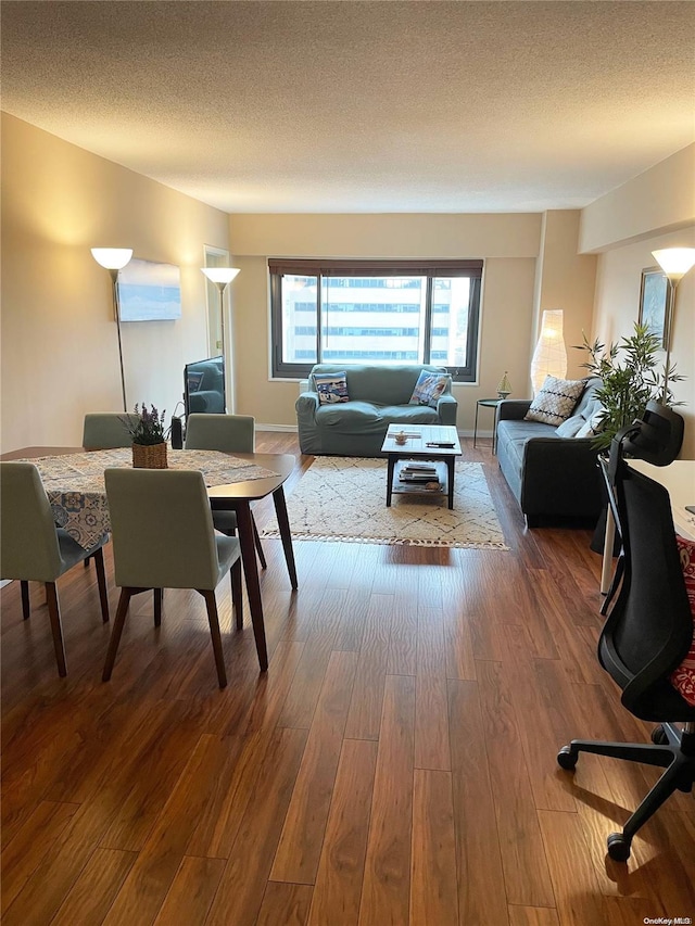 dining space with hardwood / wood-style floors and a textured ceiling