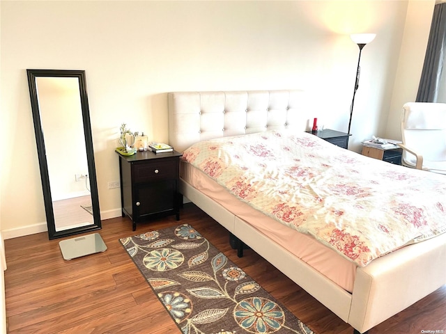 bedroom with dark hardwood / wood-style flooring