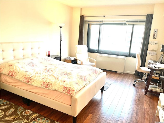 bedroom featuring dark hardwood / wood-style flooring and radiator