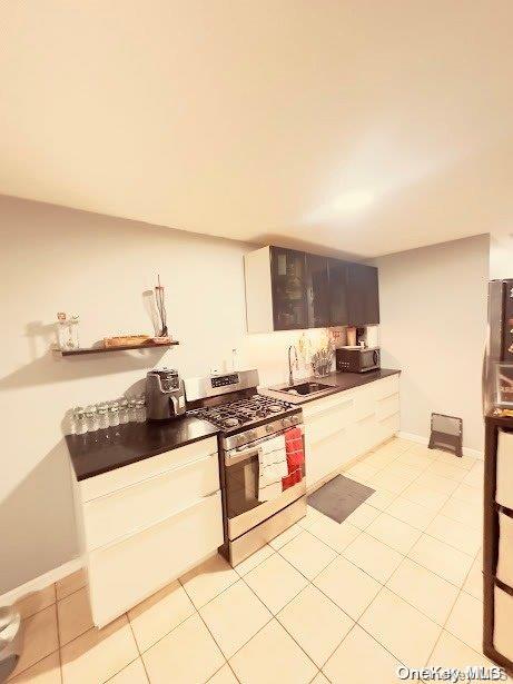 kitchen with sink, light tile patterned flooring, and stainless steel appliances