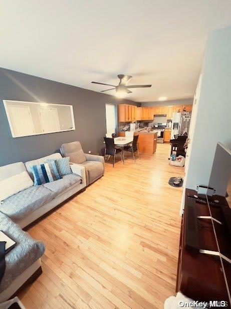 living room with ceiling fan and light wood-type flooring