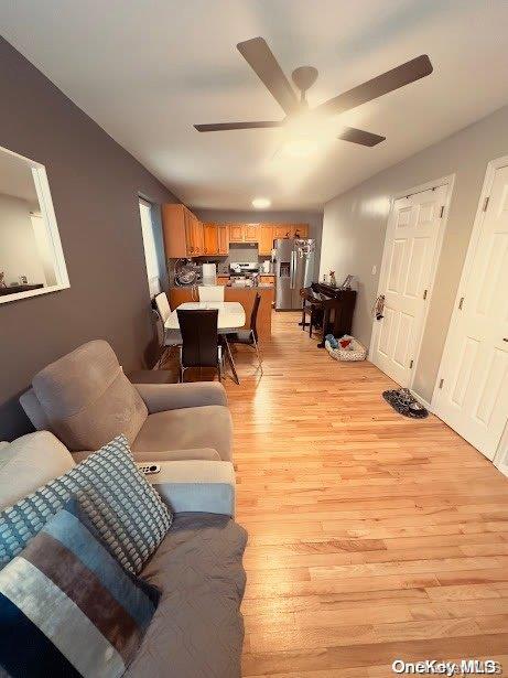 living room featuring ceiling fan and light wood-type flooring