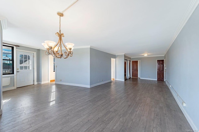 empty room with an inviting chandelier, dark wood-type flooring, and ornamental molding