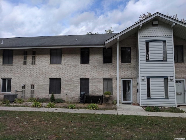 view of front facade featuring a front yard and central AC