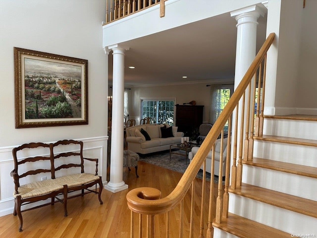 stairs featuring hardwood / wood-style floors and ornamental molding