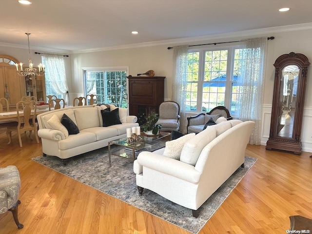 living room with crown molding, plenty of natural light, and light wood-type flooring