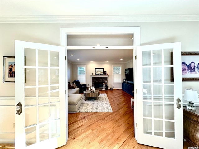 living room with a fireplace, wood-type flooring, and ornamental molding