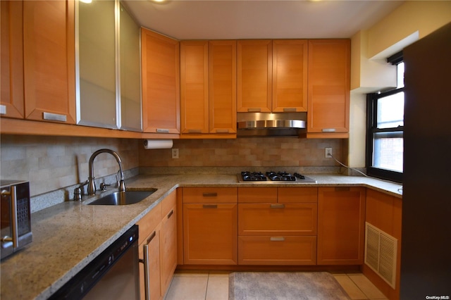 kitchen featuring sink, light tile patterned floors, stainless steel appliances, and plenty of natural light