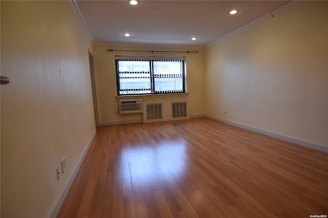 empty room with wood-type flooring, crown molding, and a wall unit AC