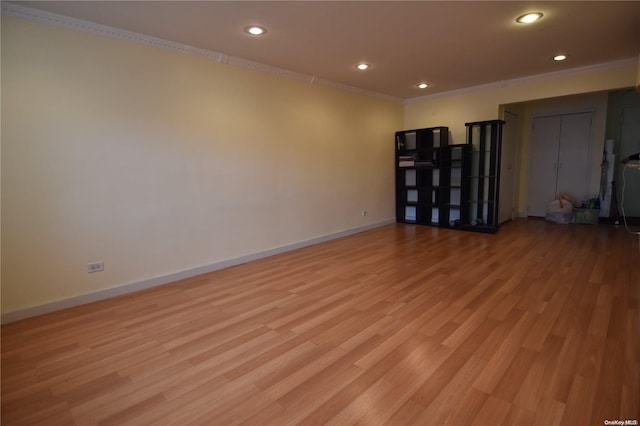 empty room featuring light hardwood / wood-style floors and crown molding